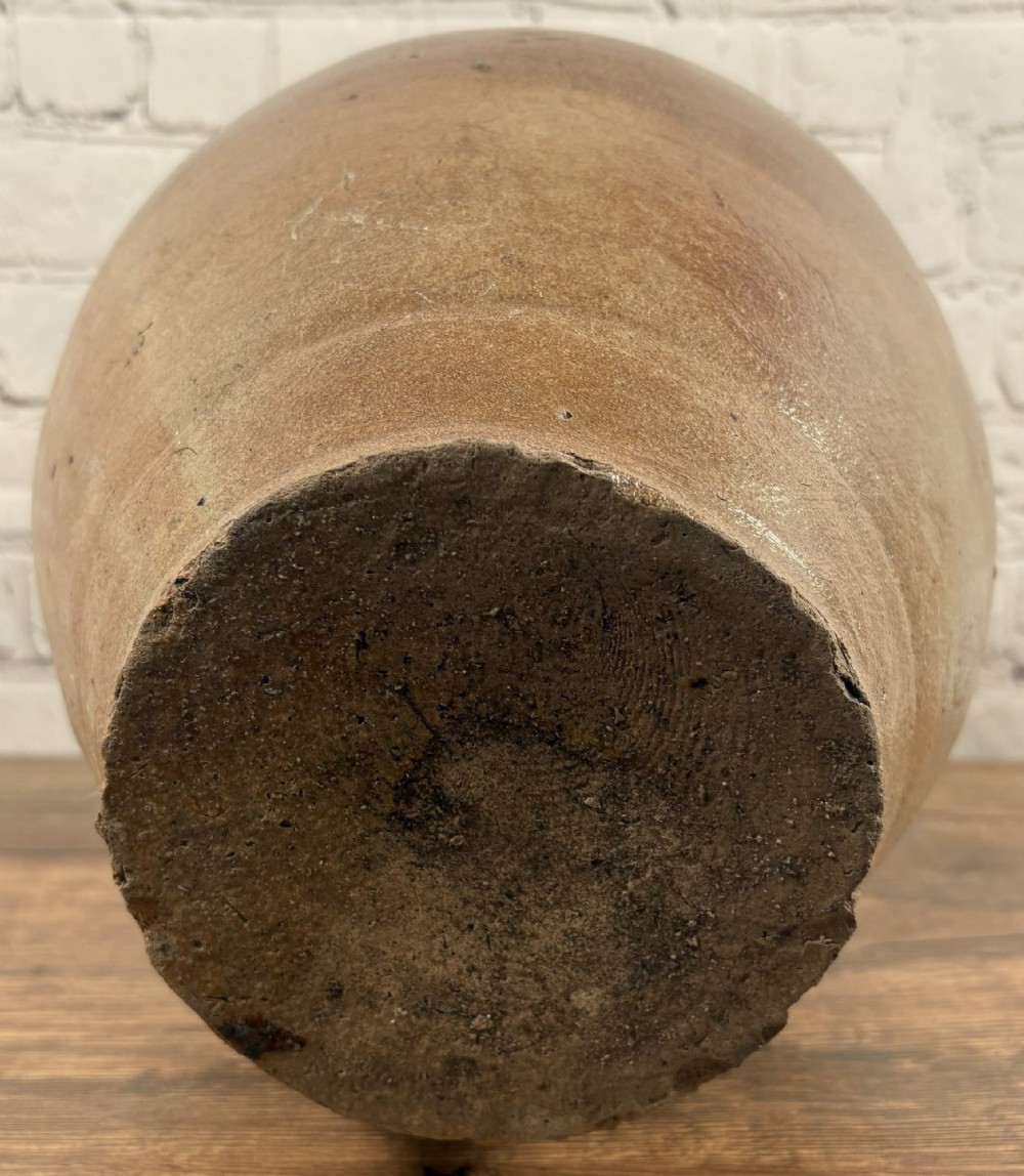 A large brown salt-glazed stoneware jug featuring a bulbous body and a relief mould of a bearded mask on the narrow neck. View VI