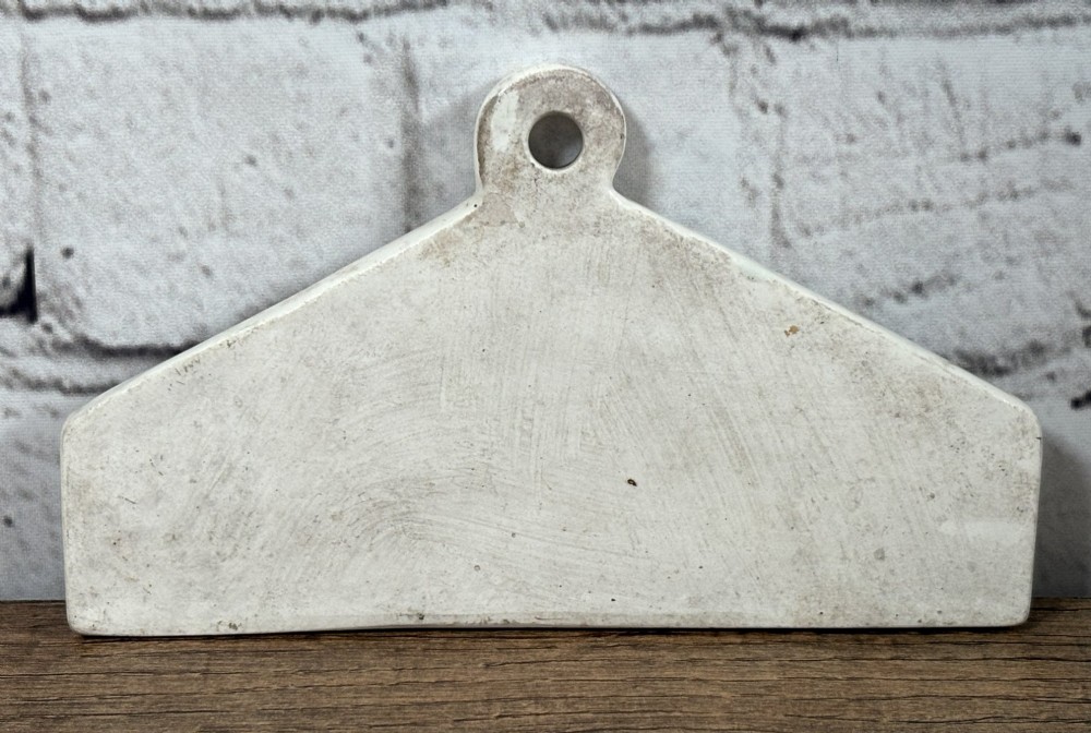 An antique off-white pottery wine bin label with a triangular top, hanging hole, and the word SHERRY printed in black serif text. View II
