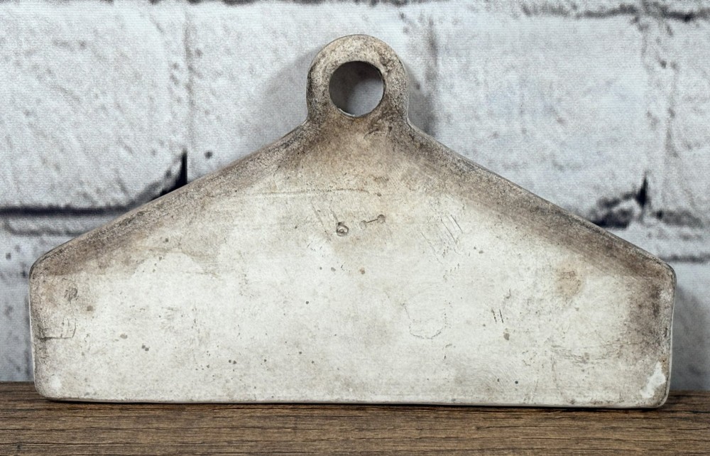 A 19th-century triangular cream ceramic wine bin label with a top hanging hole and black printed lettering reading MADEIRA. View II