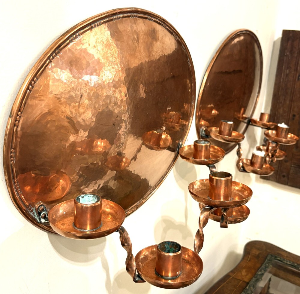 A pair of hand-hammered oval copper wall sconces featuring beaded outer borders and five curved, twisted candle branches. View VII