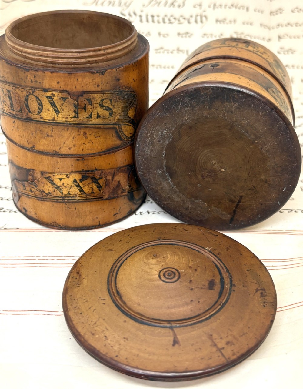A cylindrical Georgian turned wood spice tower featuring stacked compartments with printed black lettering including Cloves and Mace. View IV