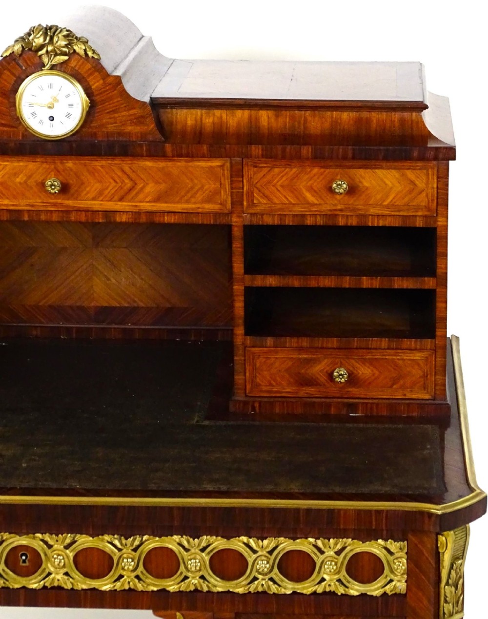 A French 19th-century kingwood writing desk with gilt-bronze ormolu mounts, upper pigeonholes and drawers, a central clock, and cabriole legs. View IV