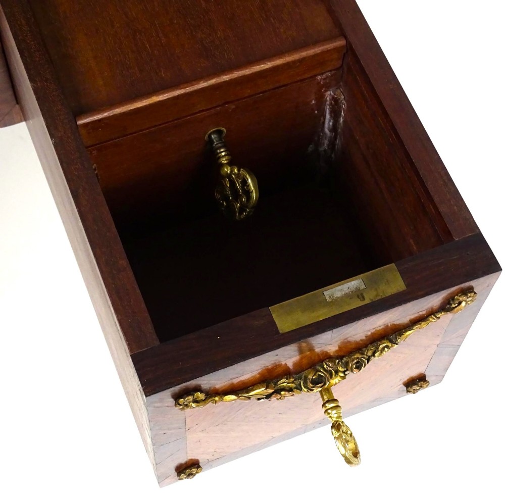 A French 19th-century kingwood writing desk with gilt-bronze ormolu mounts, upper pigeonholes and drawers, a central clock, and cabriole legs. View XII