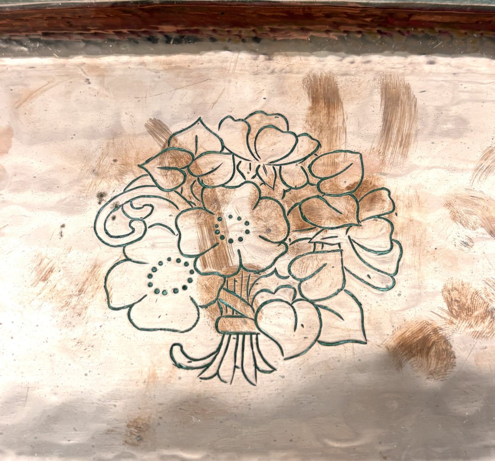 A rectangular hand-hammered copper tray featuring a central engraved floral bouquet motif, a rope-twist pewter rim, and a stamped makers mark signature. View II