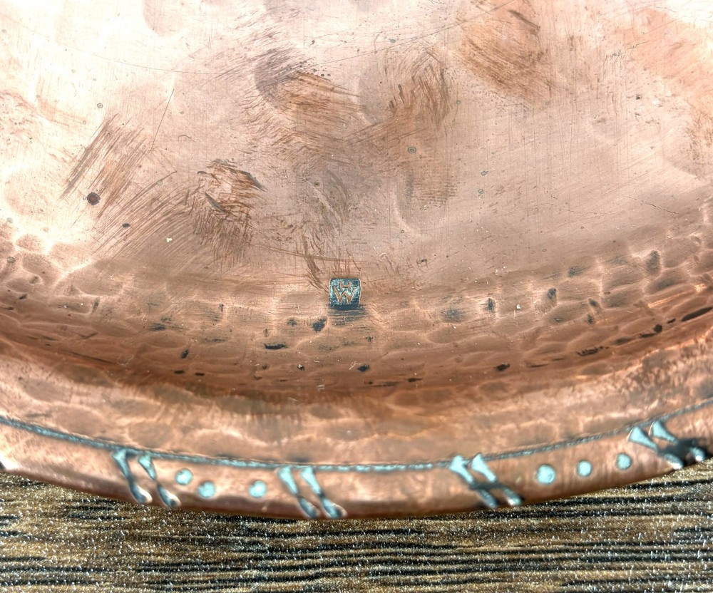 A circular hand-hammered copper tray featuring a pewter inlay of snowdrop flowers tied with a ribbon at the centre. View III