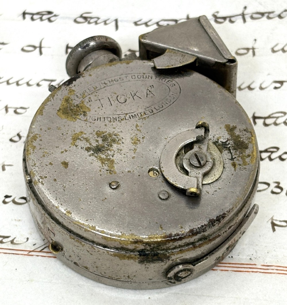 A nickel-plated Edwardian Ticka spy camera designed in the form of a pocket watch with a top-mounted viewfinder and engraved casing. View II