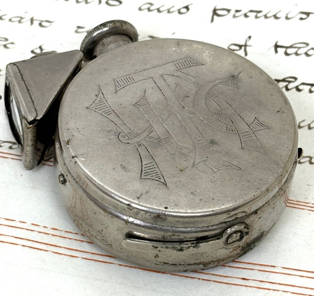 A nickel-plated Edwardian Ticka spy camera designed in the form of a pocket watch with a top-mounted viewfinder and engraved casing. View III