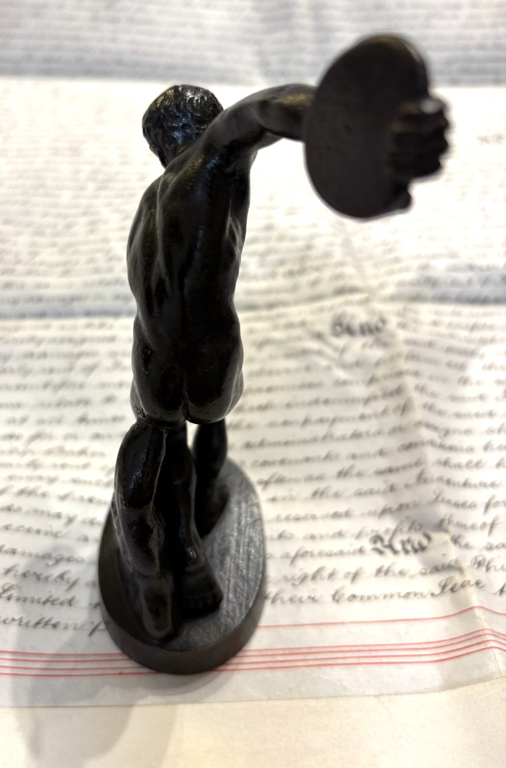 A dark patinated bronze figure depicting a male athlete in the classical Discobolus pose preparing to throw a discus. View IV