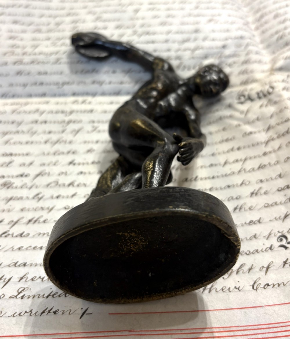 A dark patinated bronze figure depicting a male athlete in the classical Discobolus pose preparing to throw a discus. View V