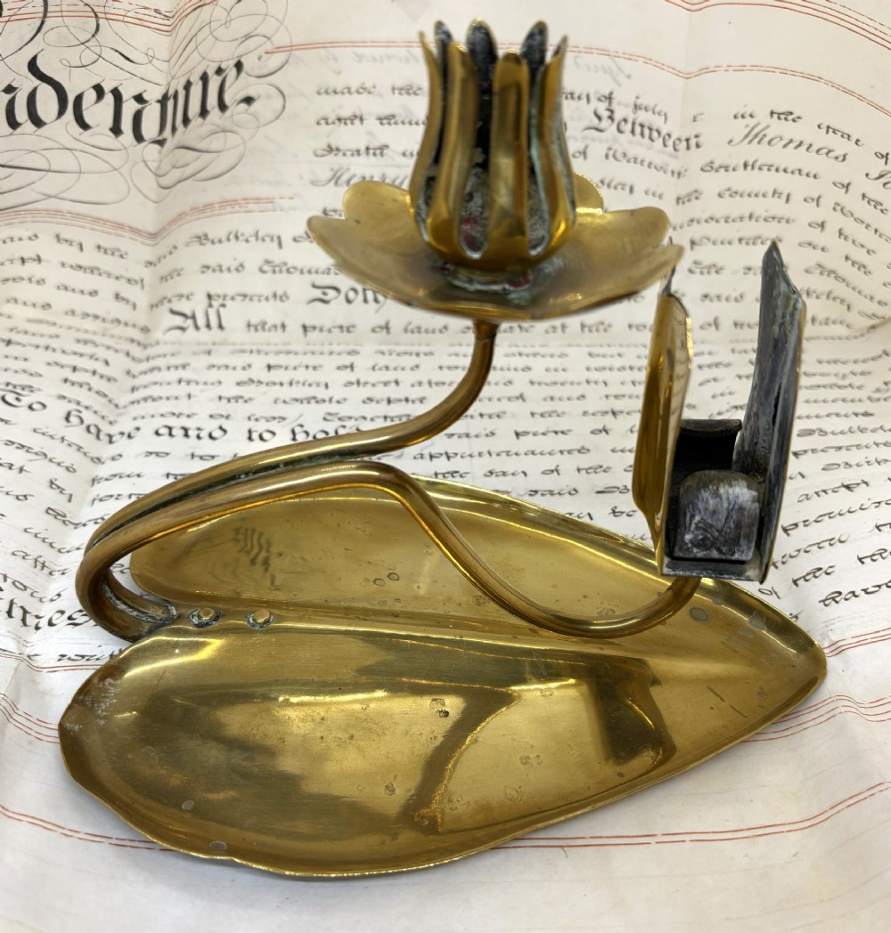 An Art Nouveau brass chamberstick featuring a leaf-shaped tray base, a curved stem supporting a tulip-form candle sconce, and an attached matchbox holder. View III