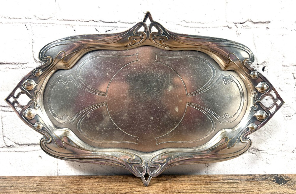 An antique rectangular silver-plated card tray featuring openwork Art Nouveau whiplash handles and engraved linear motifs in the centre.