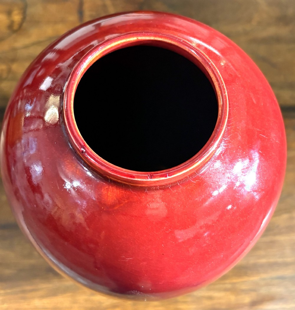 A red glazed ceramic baluster vase with a high-gloss finish. View II