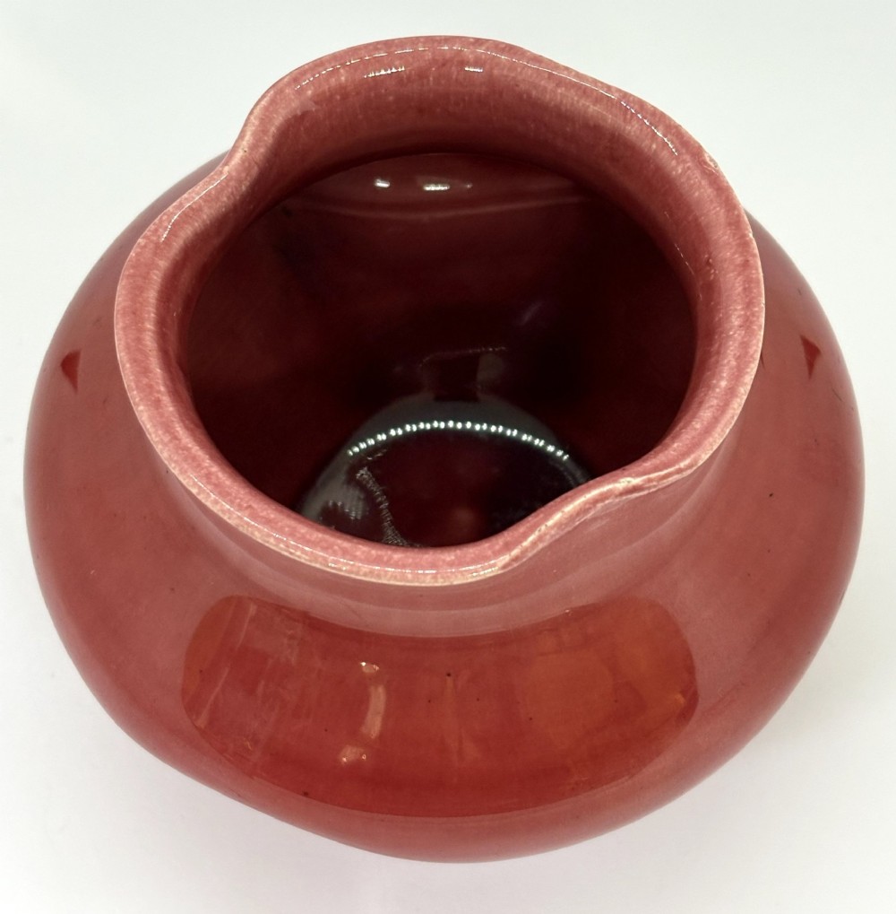 A small squat dusky pink glazed ceramic vase with a lobed rim and bulbous body. View III