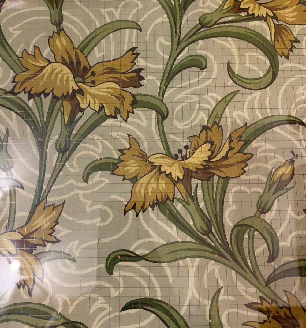 A framed Art Nouveau textile design on gridded paper featuring yellow floral motifs and green foliage against a sage background with colour swatches and technical annotations. View VI