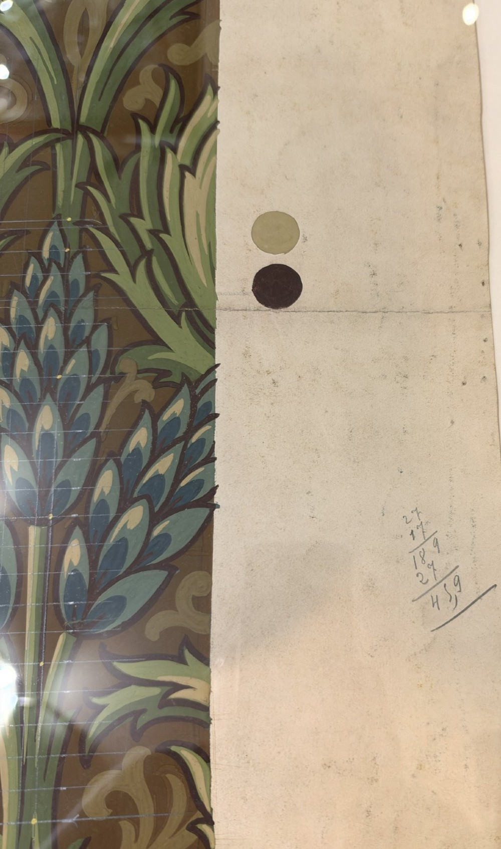 A framed antique French textile design on paper featuring stylized green leaves and blue botanical buds against a patterned brown background. View V