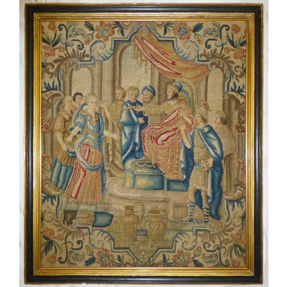 An 18th-century French needlework panel depicting classical figures within an architectural border, set in a gilt and dark wooden frame.