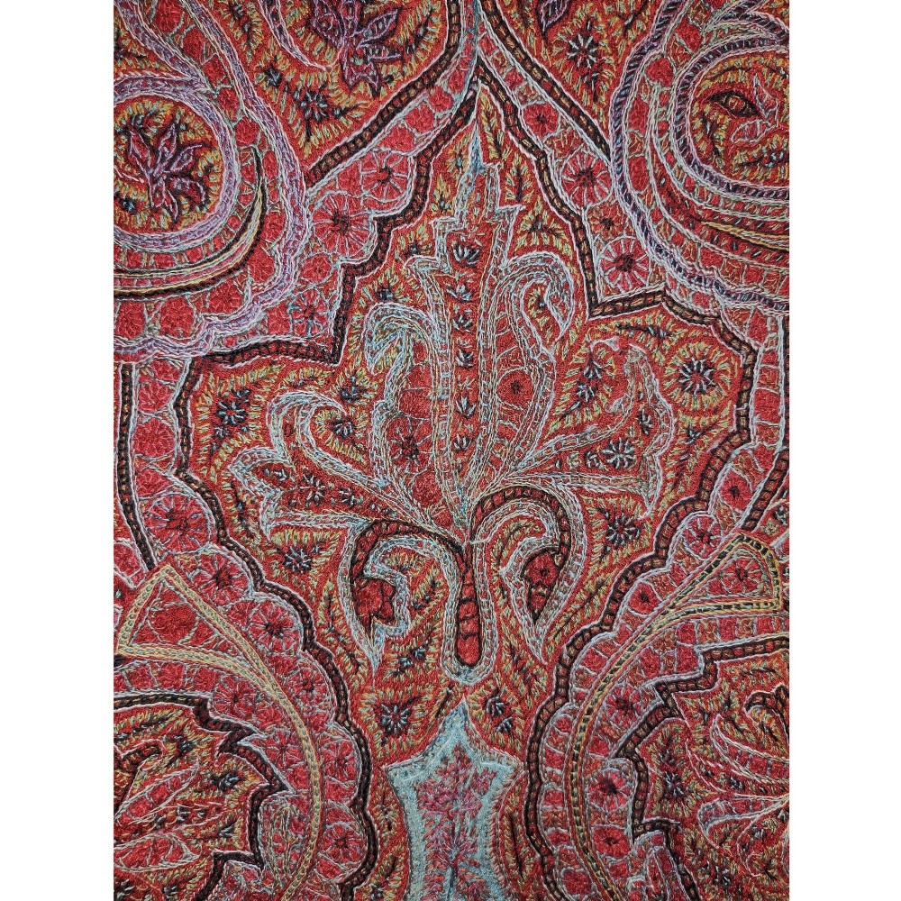 A square nineteenth-century embroidered Kashmiri shawl featuring dense red paisley boteh patterns surrounding a black star-shaped central medallion. View II