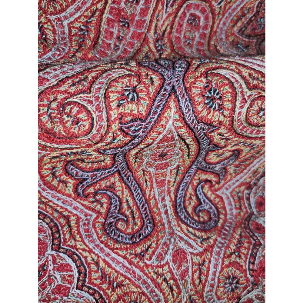 A square nineteenth-century embroidered Kashmiri shawl featuring dense red paisley boteh patterns surrounding a black star-shaped central medallion. View III