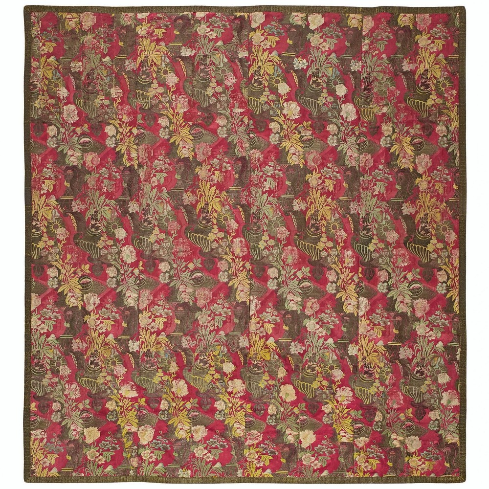 An early 18th-century square Bizarre silk textile panel featuring vertical stitched sections with asymmetrical crimson, gold, and green floral patterns.