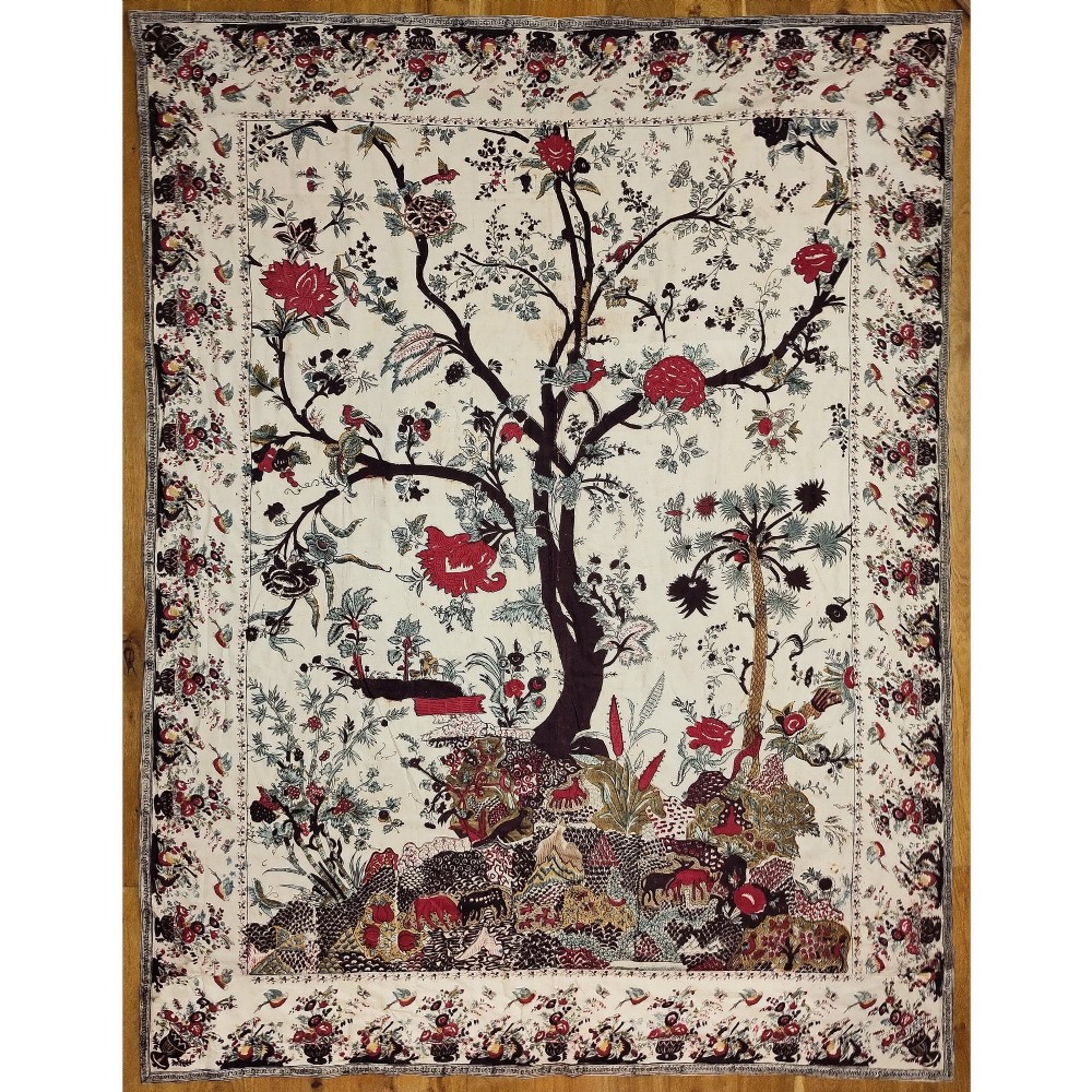 A rectangular 19th-century white cotton textile featuring a woodblock-printed tree of life design in red, green, and dark brown within an ornate floral border.