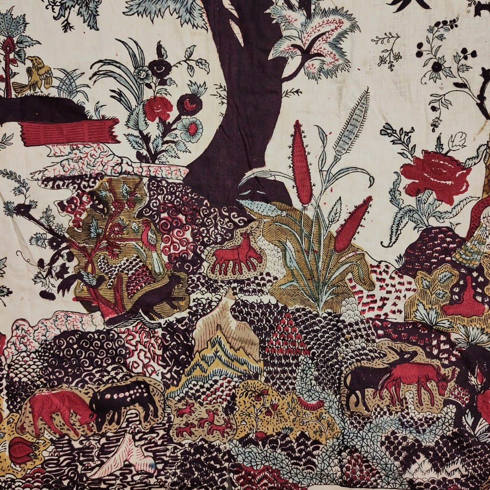 A rectangular 19th-century white cotton textile featuring a woodblock-printed tree of life design in red, green, and dark brown within an ornate floral border. View II