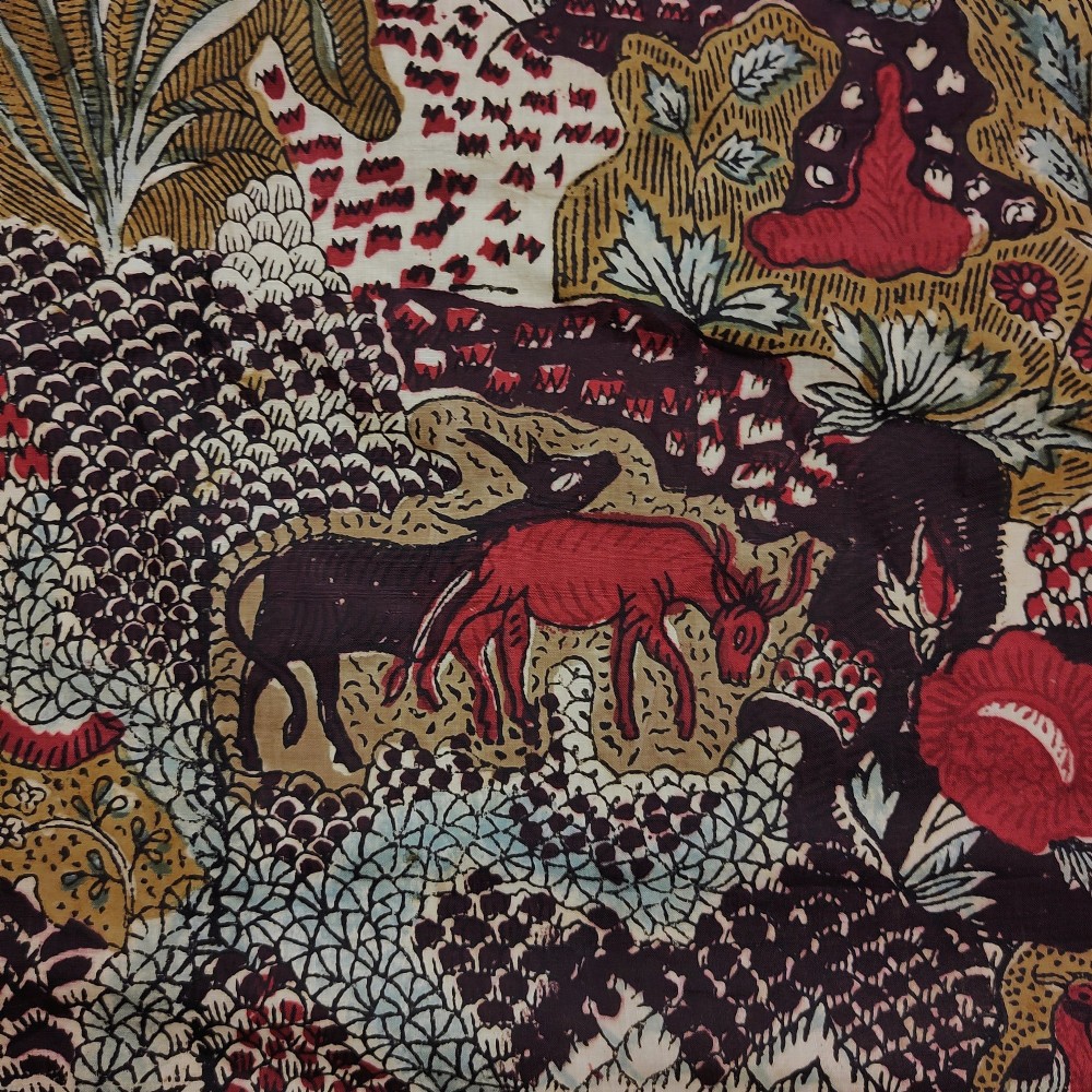 A rectangular 19th-century white cotton textile featuring a woodblock-printed tree of life design in red, green, and dark brown within an ornate floral border. View VI
