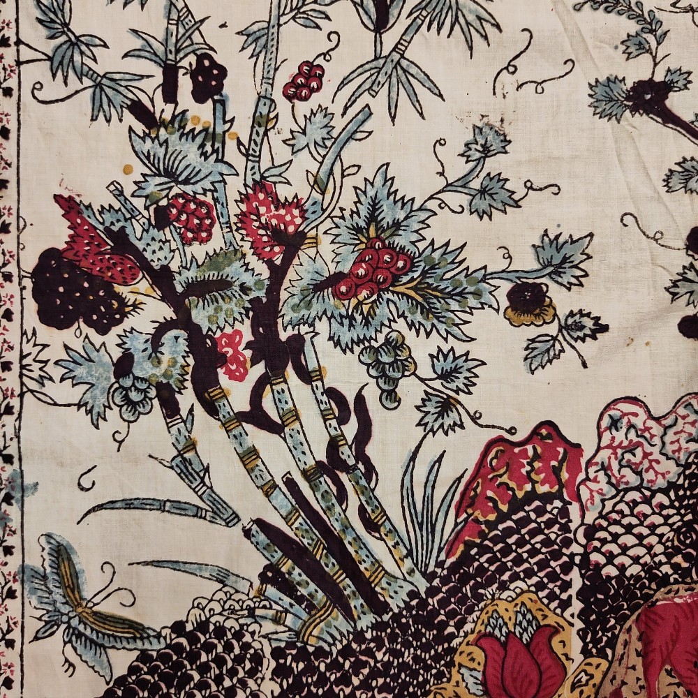 A rectangular 19th-century white cotton textile featuring a woodblock-printed tree of life design in red, green, and dark brown within an ornate floral border. View VII