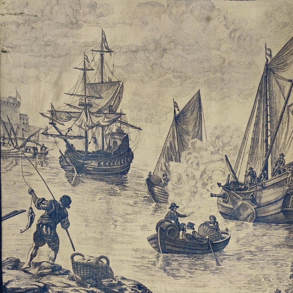 A rectangular late 19th-century toile textile panel featuring blue copperplate-printed maritime scenes on a cream cotton ground, bordered by dark navy fabric. View III