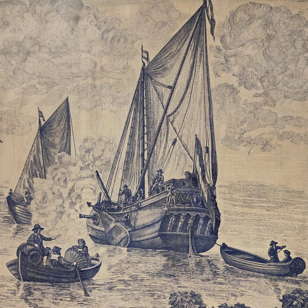 A rectangular late 19th-century toile textile panel featuring blue copperplate-printed maritime scenes on a cream cotton ground, bordered by dark navy fabric. View V