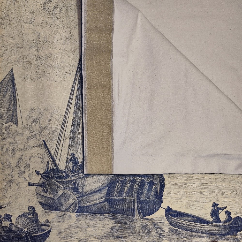 A rectangular late 19th-century toile textile panel featuring blue copperplate-printed maritime scenes on a cream cotton ground, bordered by dark navy fabric. View VI