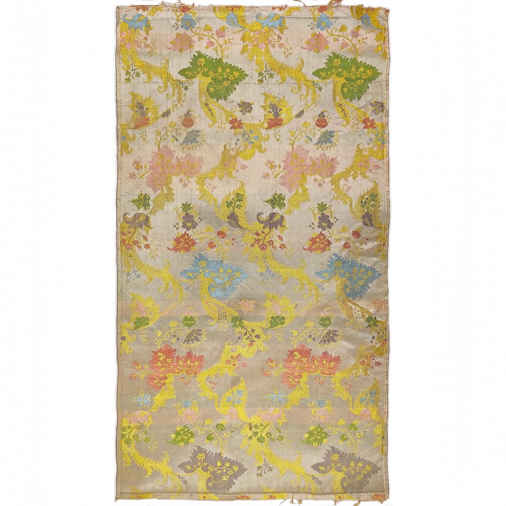 A rectangular length of 18th-century Spitalfields Bizarre silk lampas featuring colourful asymmetrical woven motifs on a muted ground.
