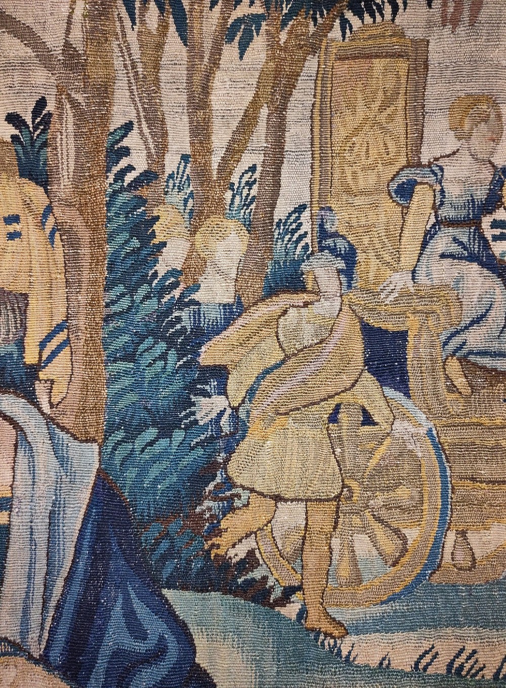 A tall rectangular Flemish tapestry panel depicting a woman and man in Renaissance attire standing in a wooded landscape. View V