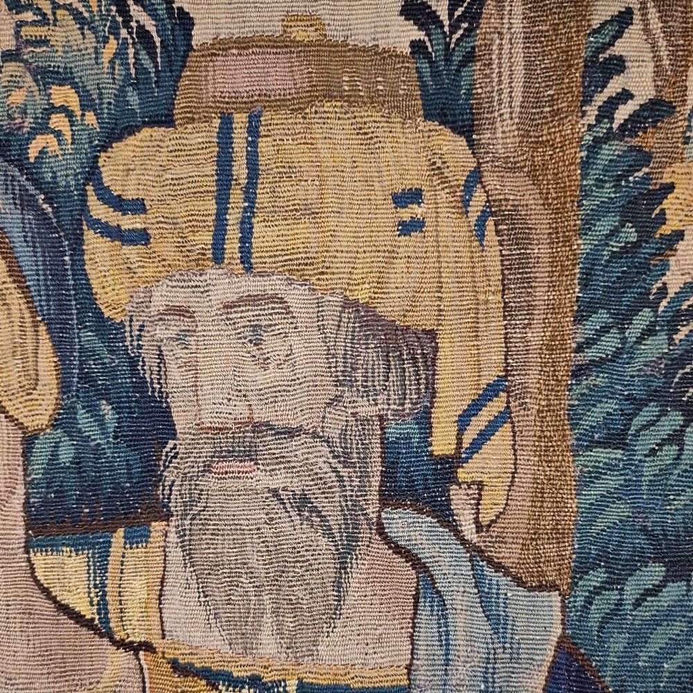 A tall rectangular Flemish tapestry panel depicting a woman and man in Renaissance attire standing in a wooded landscape. View VII