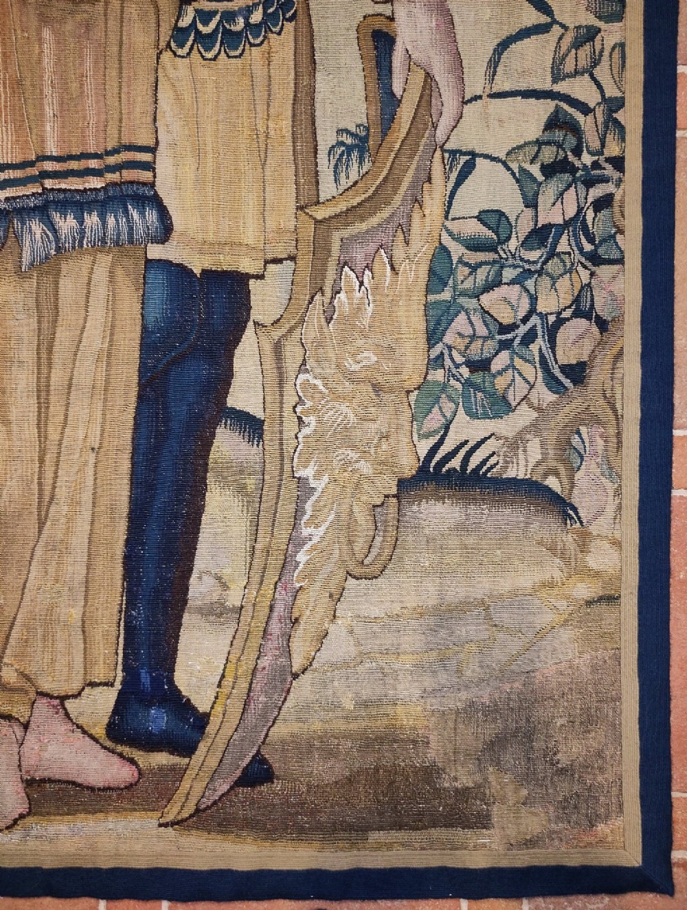 A tall rectangular Flemish tapestry panel depicting a woman and man in Renaissance attire standing in a wooded landscape. View IX