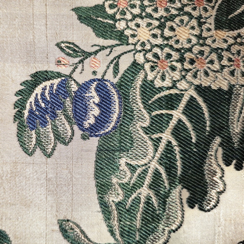 An 18th-century floral woven Spitalfields silk panel with green leaves and pastel blossoms, presented inside a dark wood rectangular frame. View V