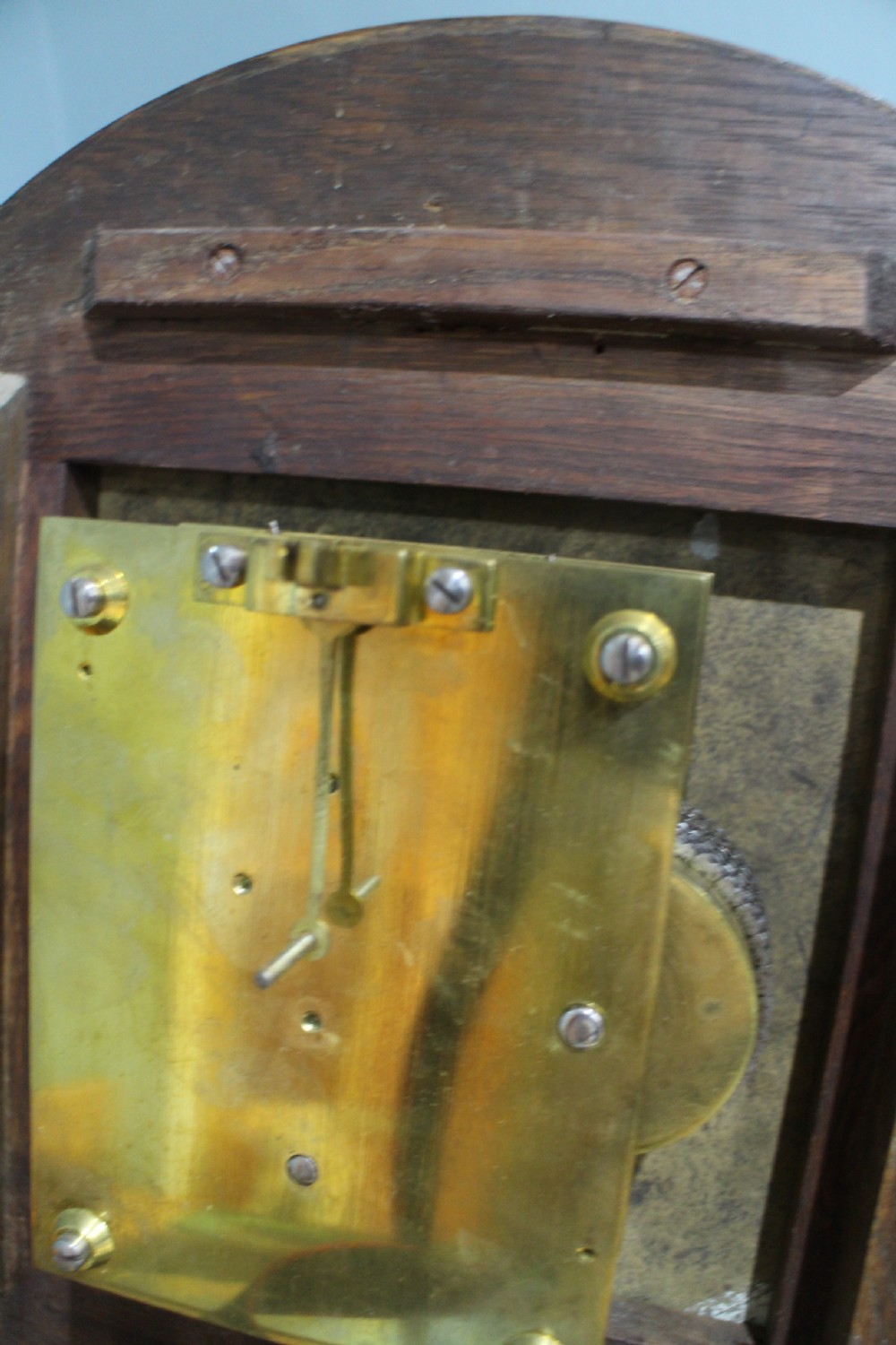 A circular Victorian fusee dial clock featuring a dark wood surround, a black dial signed C. Frodsham London with gilt Roman numerals, and ornate brass hands. View IV