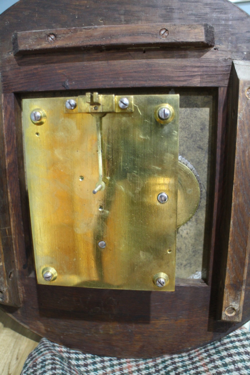 A circular Victorian fusee dial clock featuring a dark wood surround, a black dial signed C. Frodsham London with gilt Roman numerals, and ornate brass hands. View V