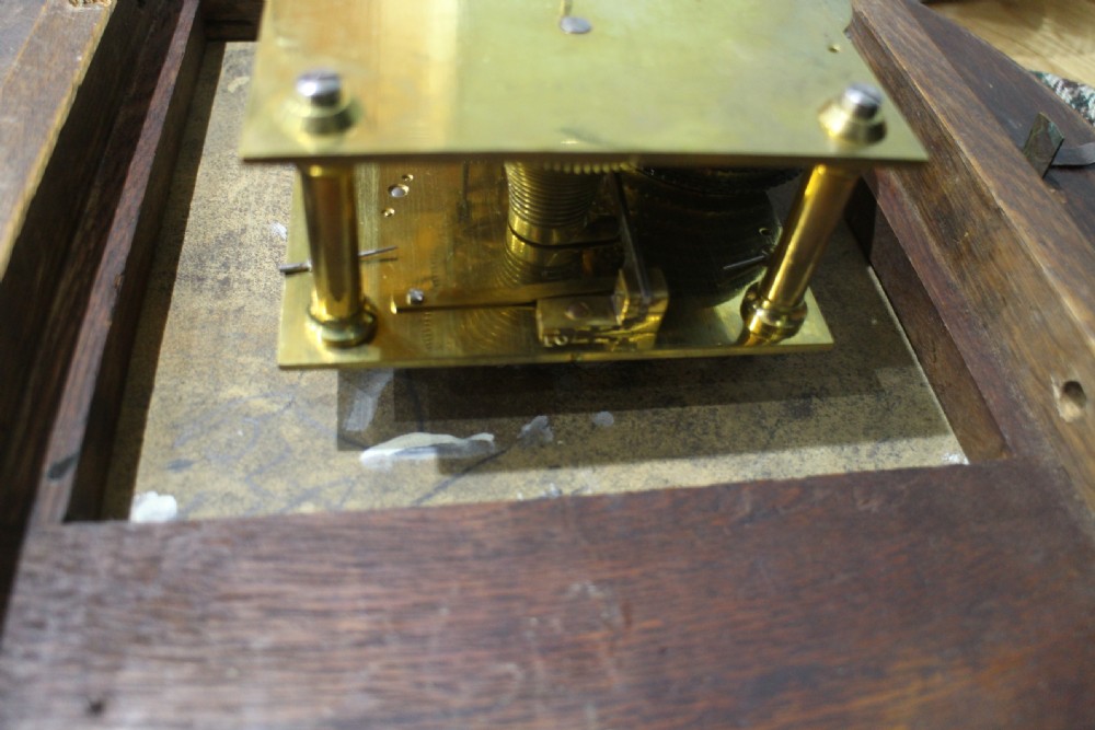 A circular Victorian fusee dial clock featuring a dark wood surround, a black dial signed C. Frodsham London with gilt Roman numerals, and ornate brass hands. View VII