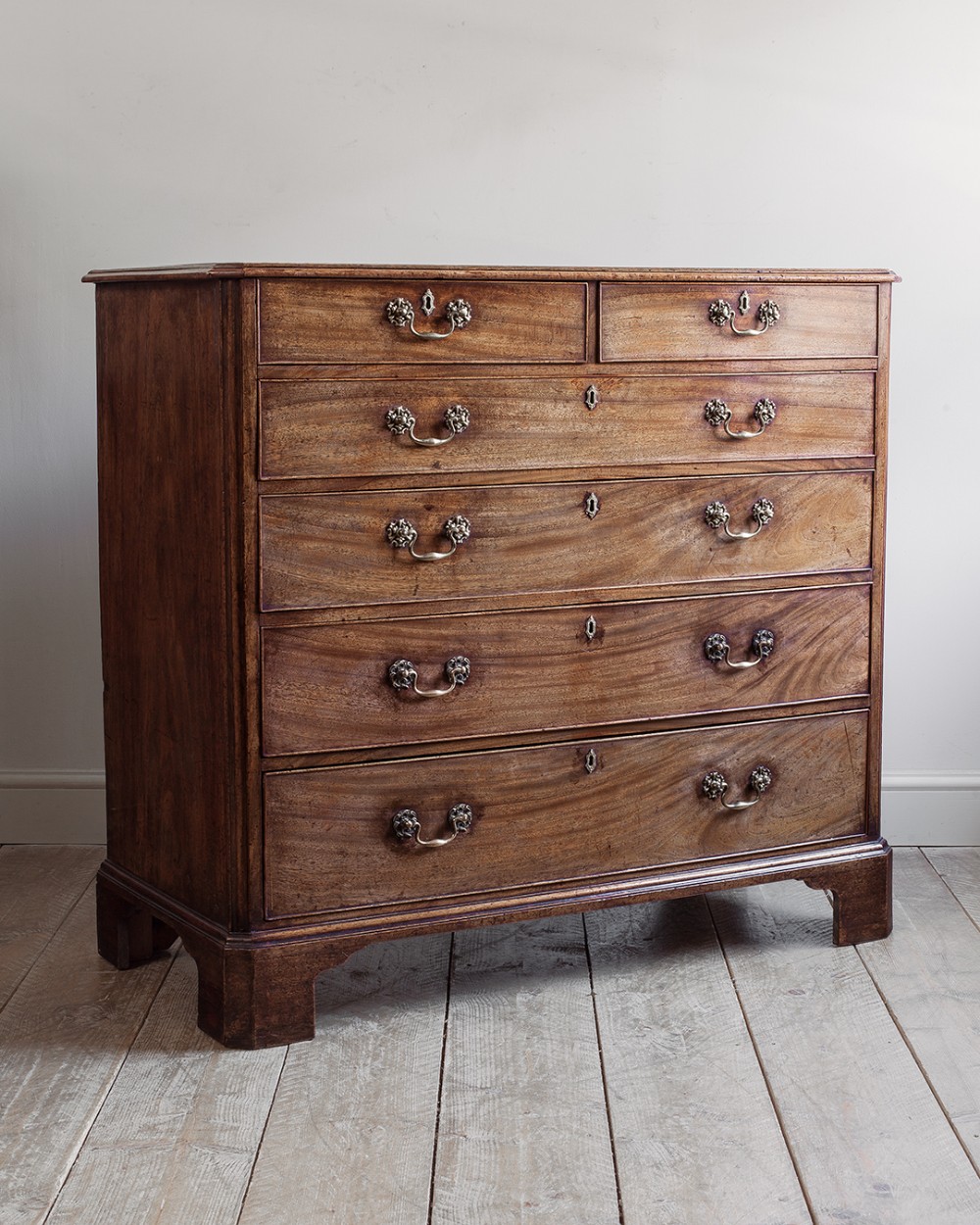 A large George III mahogany chest of drawers featuring two short drawers above four long graduated drawers on bracket feet.