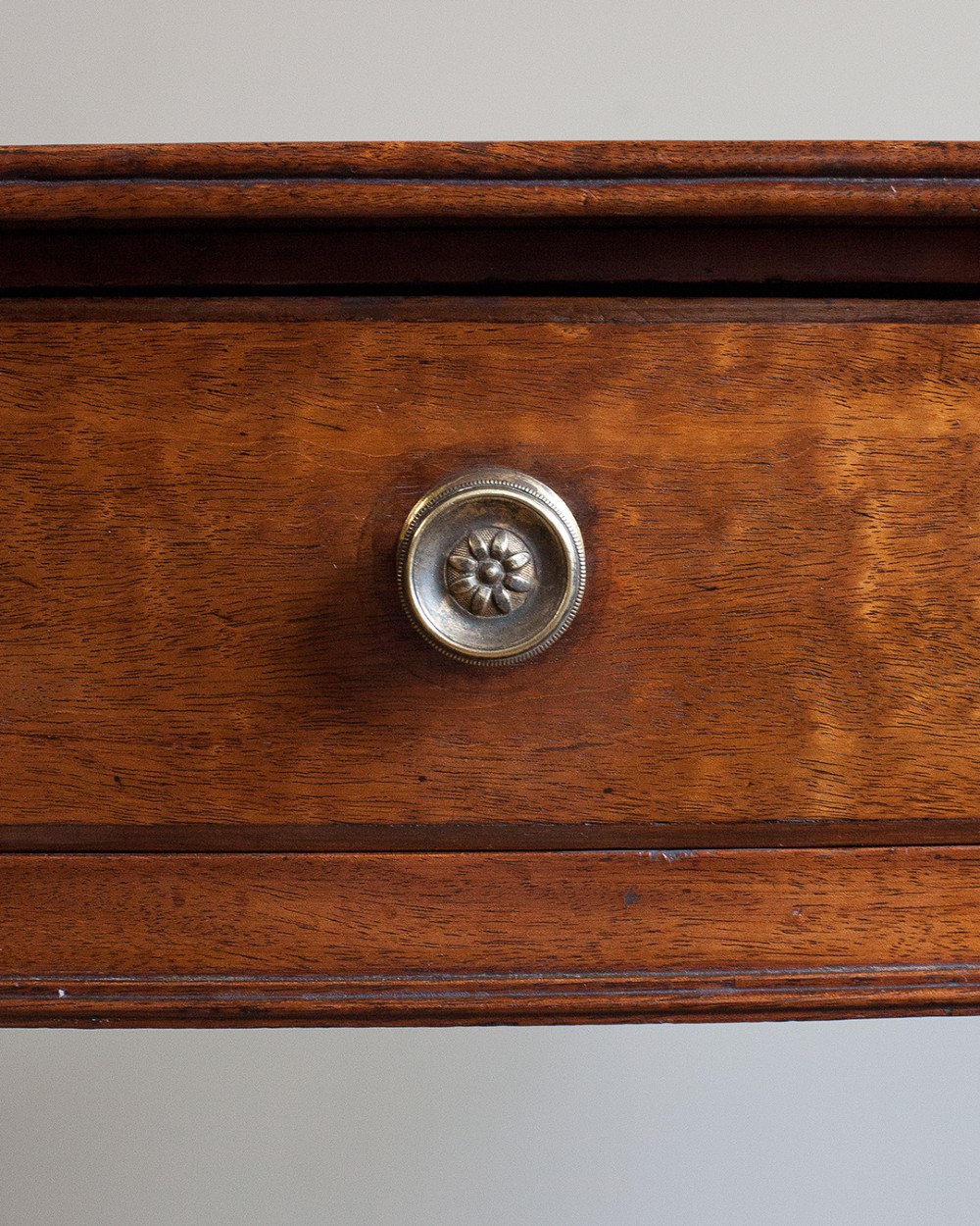 A nineteenth-century mahogany bowfront side table featuring a single drawer with two brass knobs and four ring-turned legs. View IV