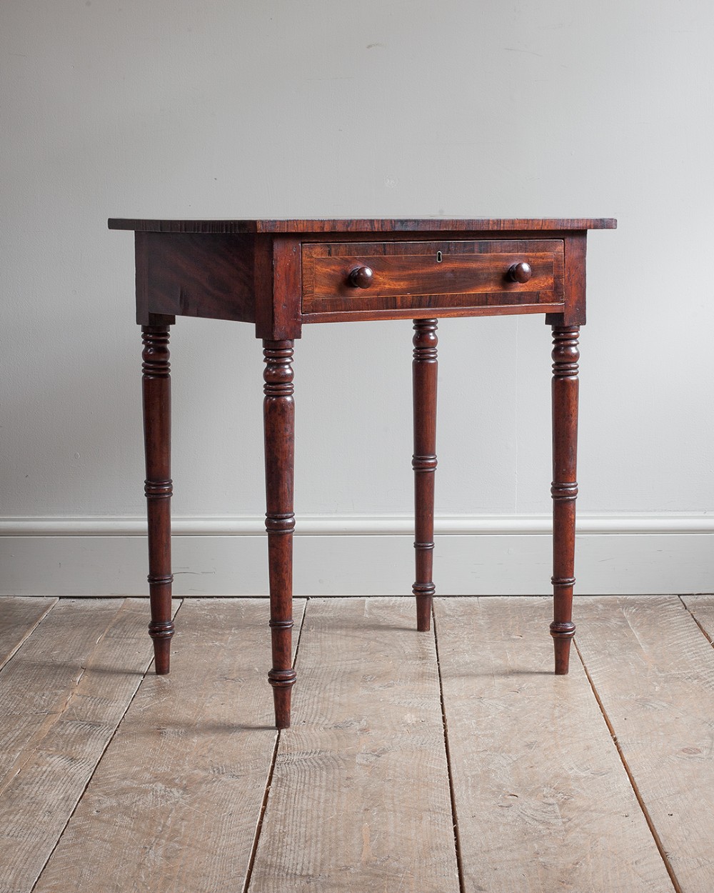 A small George IV mahogany side table featuring a single drawer with wooden knobs and slender turned legs. View VI