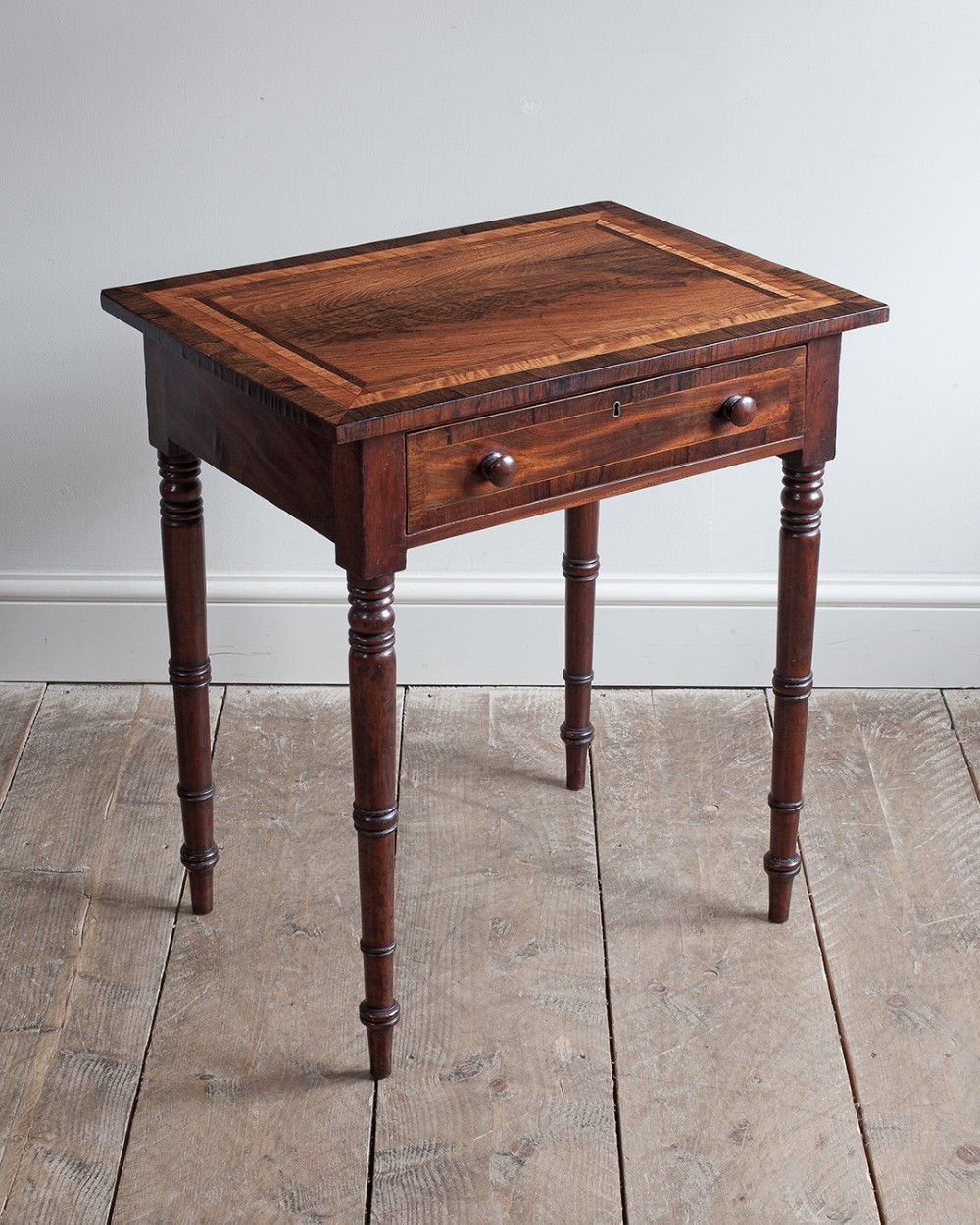 A small George IV mahogany side table featuring a single drawer with wooden knobs and slender turned legs. View VII