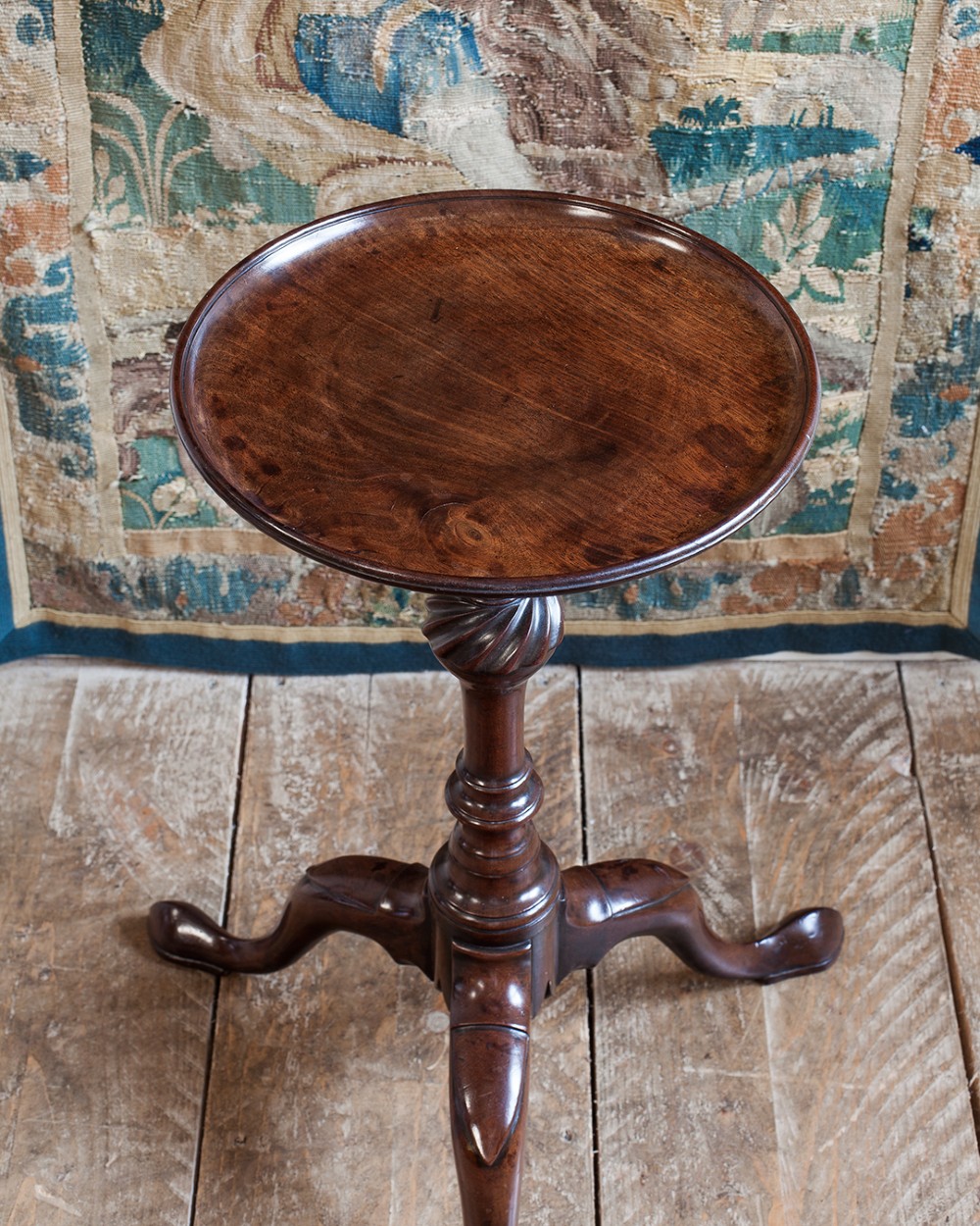 A Georgian dark mahogany kettle stand with a dished circular top, a turned stem with spiral fluting, and three cabriole legs. View II
