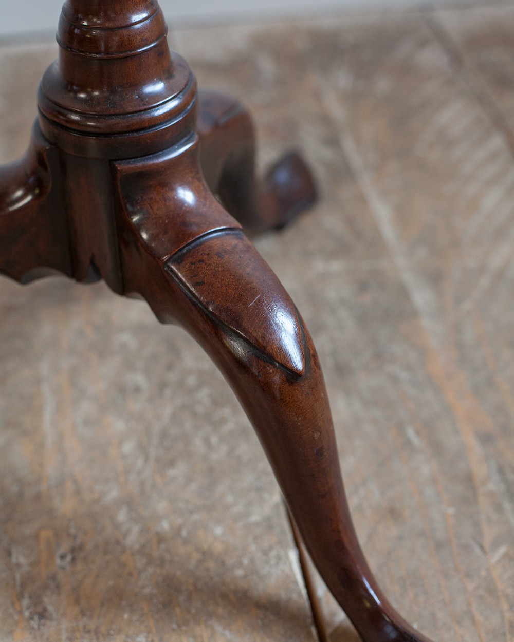 A Georgian dark mahogany kettle stand with a dished circular top, a turned stem with spiral fluting, and three cabriole legs. View V