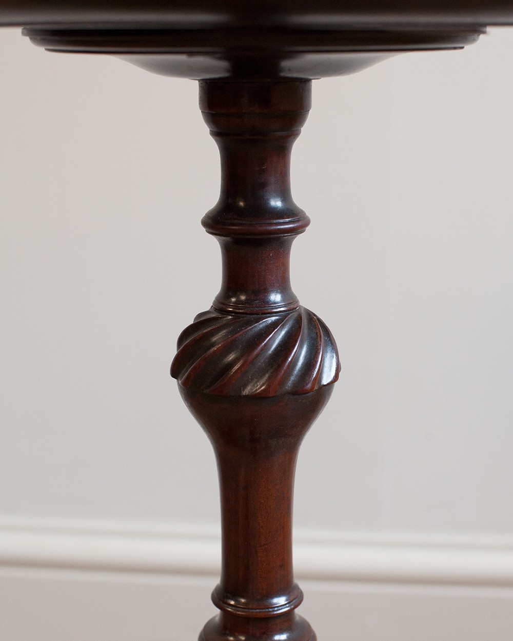 A Georgian dark mahogany kettle stand with a dished circular top, a turned stem with spiral fluting, and three cabriole legs. View VI
