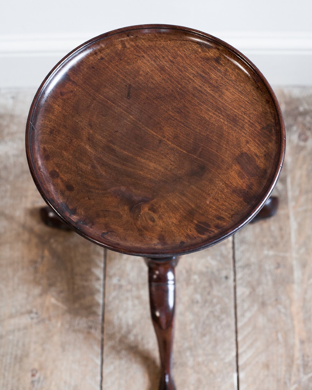 A Georgian dark mahogany kettle stand with a dished circular top, a turned stem with spiral fluting, and three cabriole legs. View VII