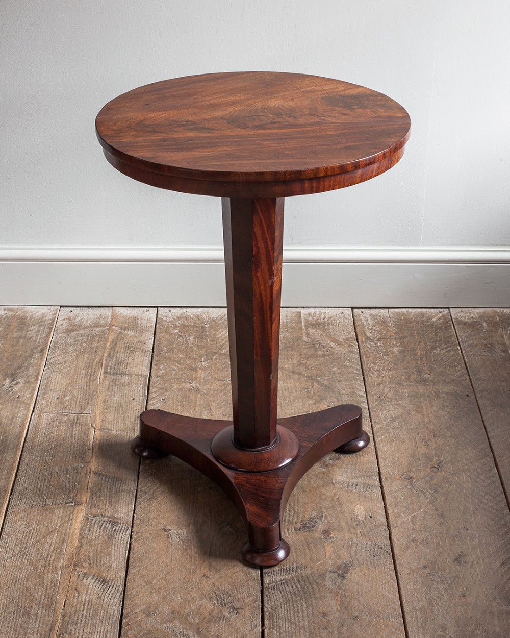 A 19th-century mahogany lamp table featuring a round top supported by a tapered octagonal pedestal stem and a triform base with flattened feet. View II