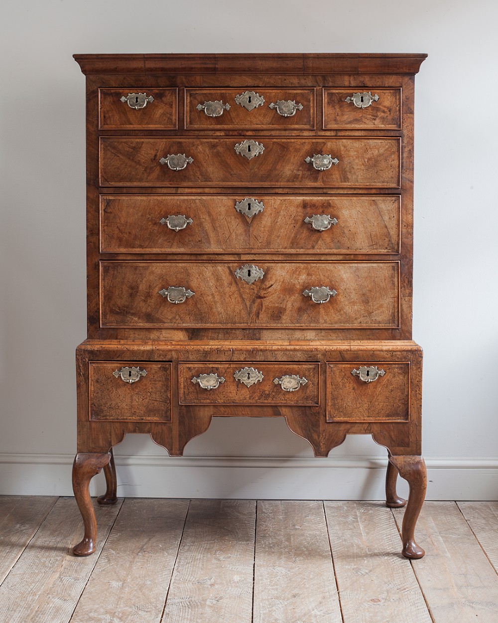 A two-part Georgian walnut chest on stand featuring multiple drawers with brass handles and escutcheons, supported by cabriole legs. View II