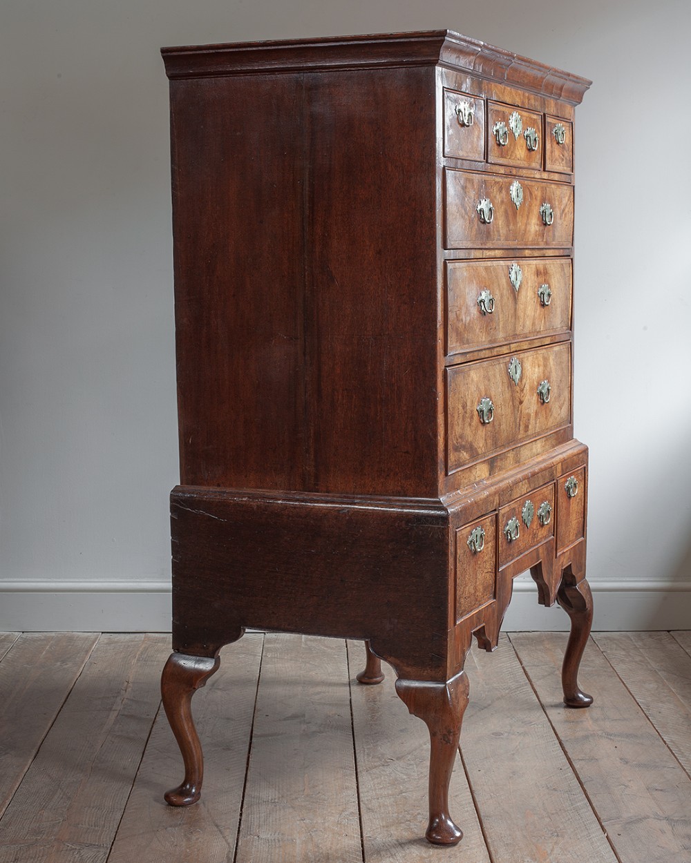 A two-part Georgian walnut chest on stand featuring multiple drawers with brass handles and escutcheons, supported by cabriole legs. View V