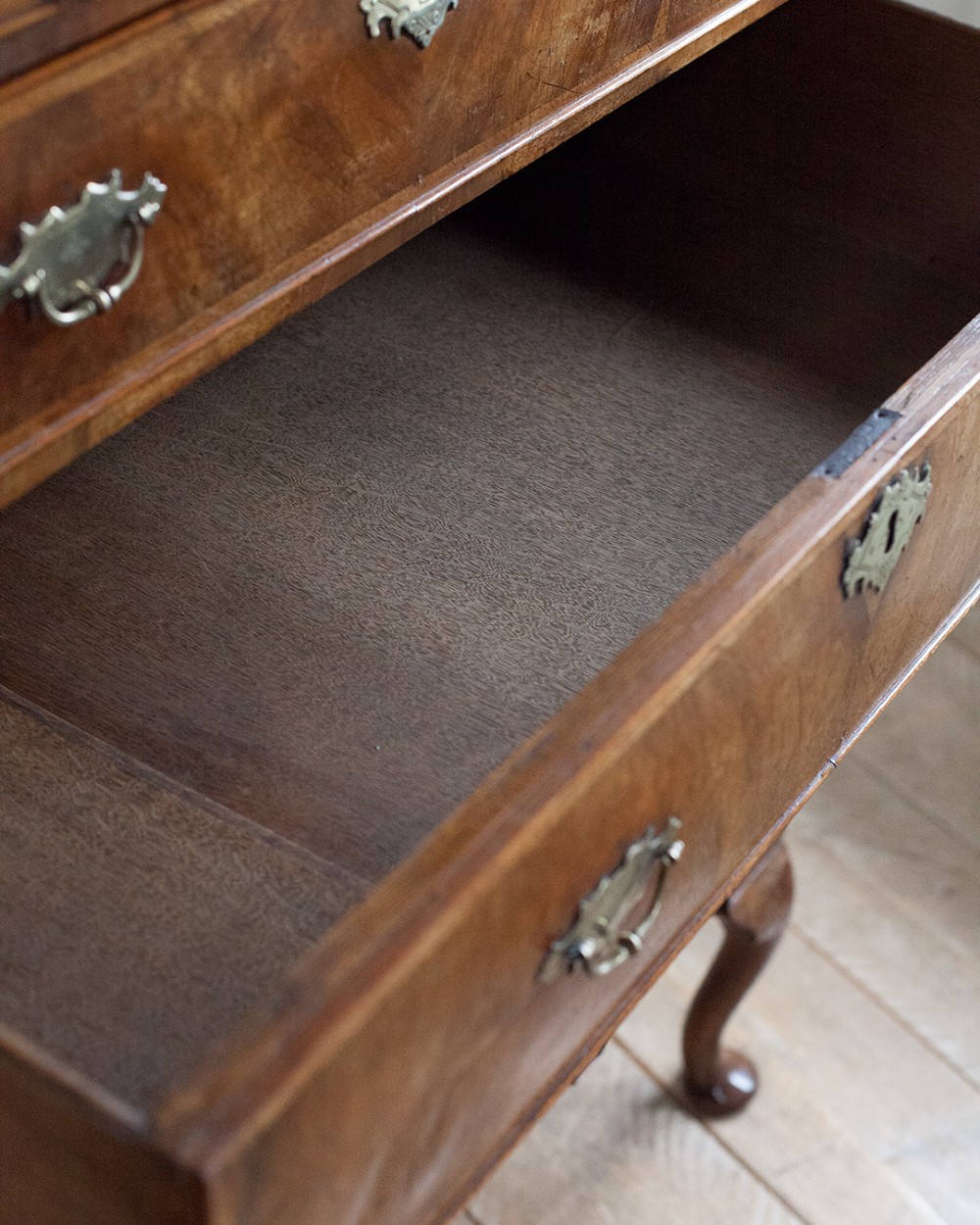 A two-part Georgian walnut chest on stand featuring multiple drawers with brass handles and escutcheons, supported by cabriole legs. View VI